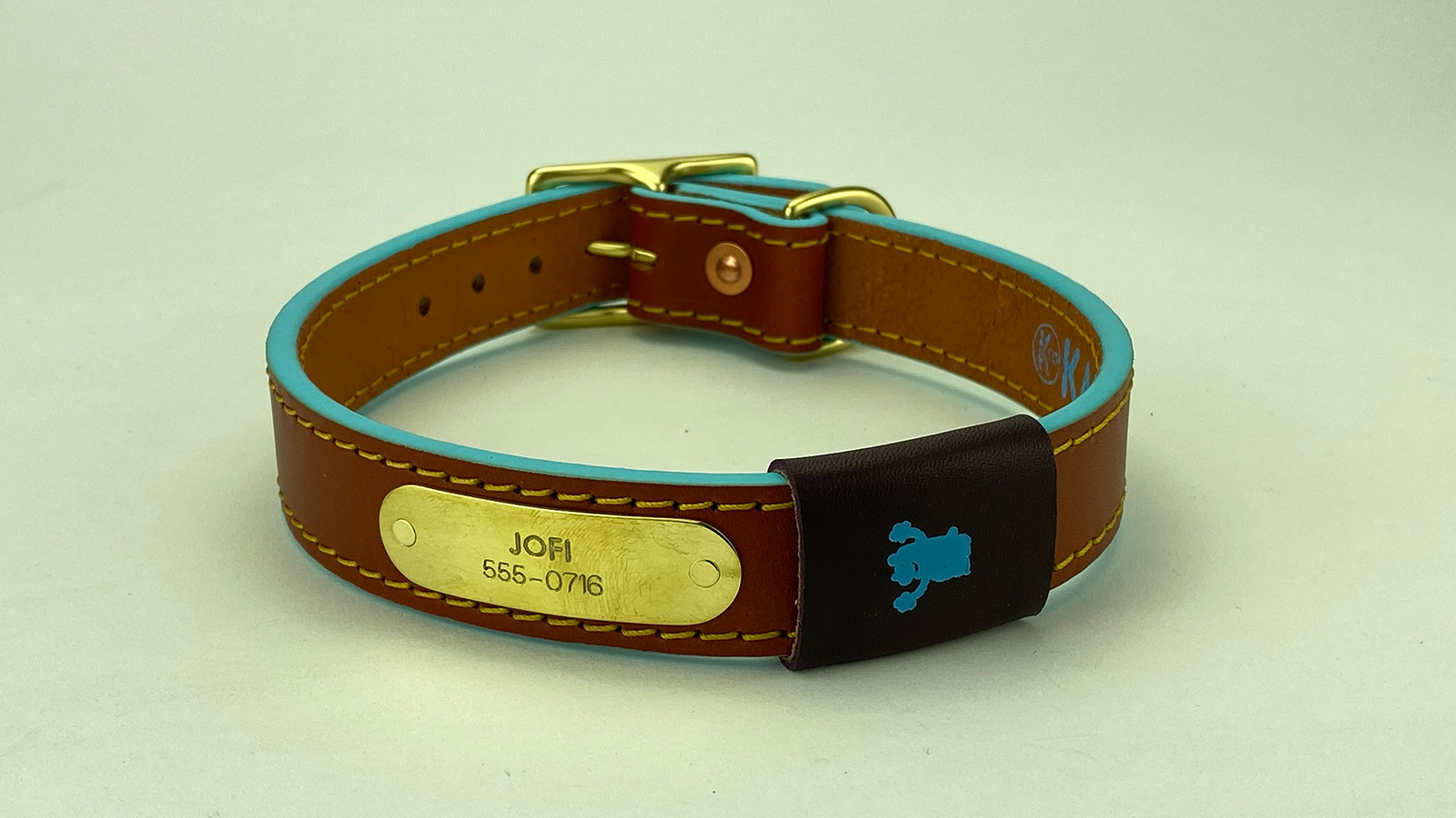 #5. Chestnut leather, old gold stitch, robin egg blue edge, plum badge. Shown with natural brass hardware.